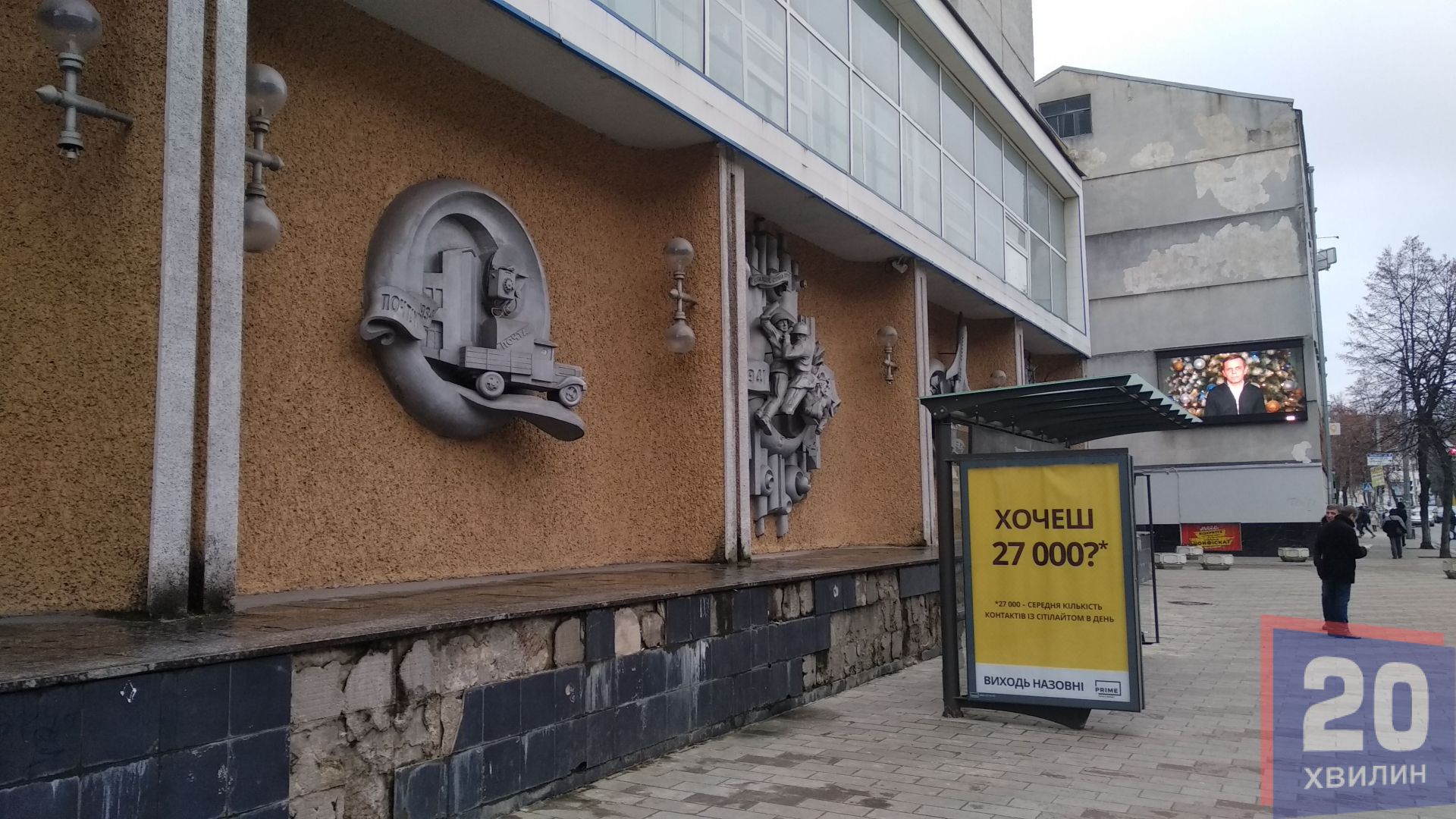 Міський голова вітає містян з екрану на фоні будівлі Укртелекому з зруйнованими барельєфами